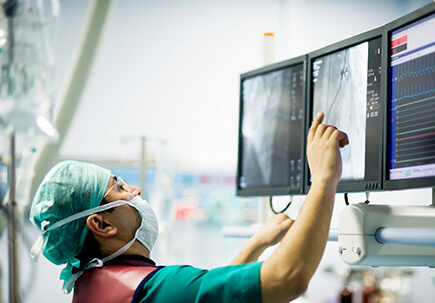 Doctor in surgery working on screens Doctor in surgery working on screens